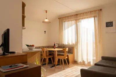 a kitchen and living room with a table and chairs at Fewo Zweiraum im Haus Götsch 5 in Parcines