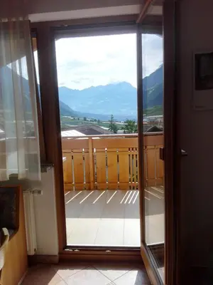 a door to a balcony with a view of mountains at Fewo Zweiraum im Haus Götsch 5 in Parcines