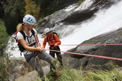 two people crossing a rope bridge over a waterfall at Fewo Dreiraum im Haus Götsch 3 in Parcines