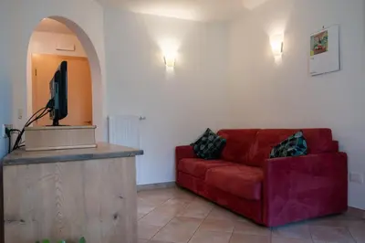 a living room with a red couch and a podium at Fewo Dreiraum im Haus Götsch 2 in Parcines