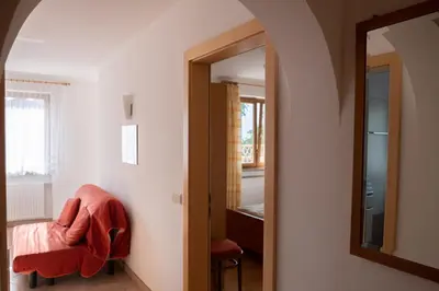 a room with a chair and a mirror at Fewo Zweiraum im Haus Götsch 1 in Parcines