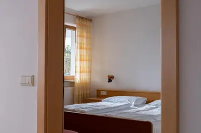 a reflection of a bedroom with two beds and a mirror at Fewo Zweiraum im Haus Götsch 1 in Parcines