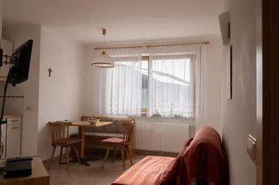 a living room with a table and a window at Fewo Zweiraum im Haus Götsch 1 in Parcines