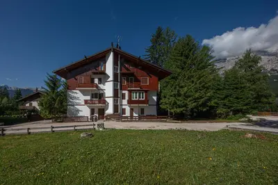 a large building with a gambrel roof at Cortina-House in Cortina dʼAmpezzo