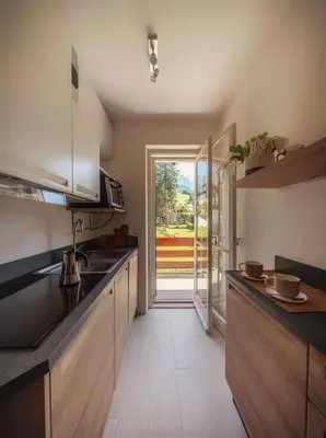 a kitchen with a sink and a door to a yard at Cortina-House in Cortina dʼAmpezzo