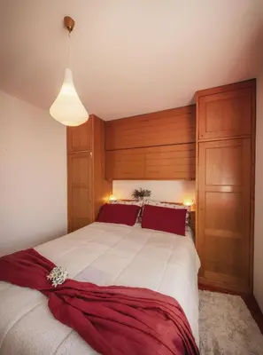 a bedroom with a large bed with a wooden headboard at Cortina-House in Cortina dʼAmpezzo