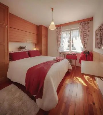 a bedroom with a large bed and a window at Cortina-House in Cortina dʼAmpezzo