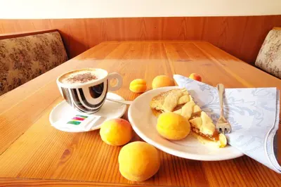 a table with a plate of bread and a cup of coffee at Rifugio Palafavera in Val di Zoldo