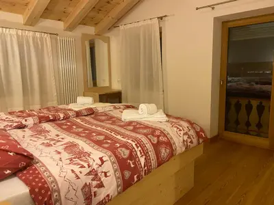 a bedroom with a bed with towels on it at Rifugio Palafavera in Val di Zoldo