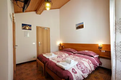 a bedroom with a bed with towels on it at Rifugio Palafavera in Val di Zoldo