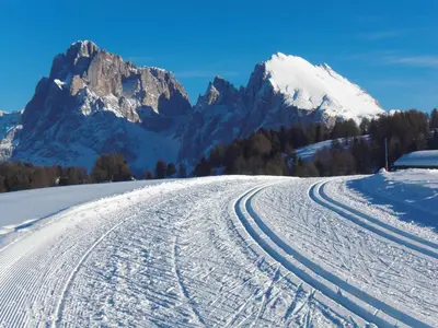 a snow covered road with mountains in the background at Appartements Karbon in Seiser Alm