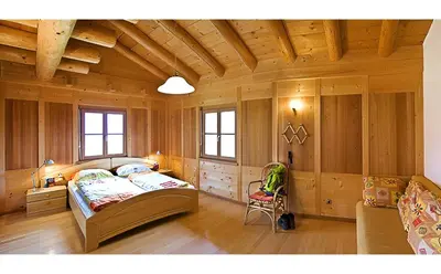 a bedroom with a bed and a chair in a room at Appartements Karbon in Seiser Alm