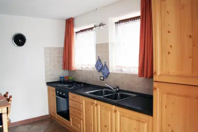 a kitchen with a sink and two windows at Appartamenti Piazzi in Tesero