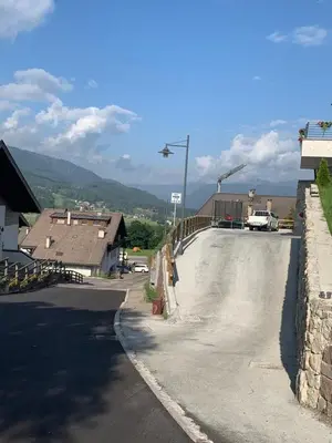 a parking lot with a road and a street light at Appartamenti Piazzi in Tesero