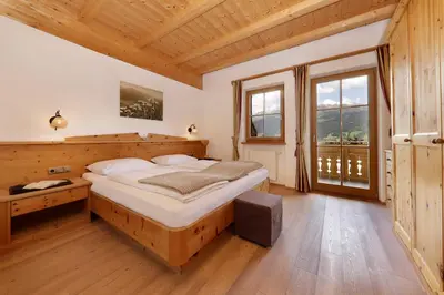 a bedroom with a large bed and a large window at Nestlhof in Racines