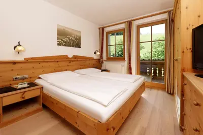 a bedroom with a large bed and a television at Nestlhof in Racines