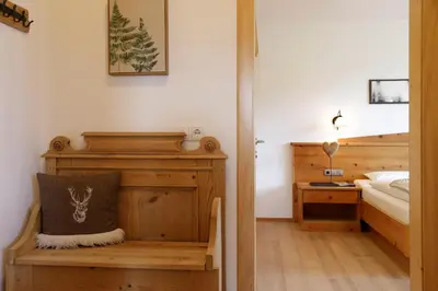 a bedroom with a bed and a bench in a room at Nestlhof in Racines