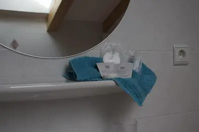 a bathroom sink with a blue towel and a mirror at Cafe Schneider in Lappago