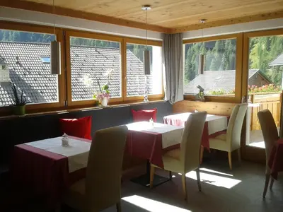 a restaurant with two tables and chairs and windows at Cafe Schneider in Lappago