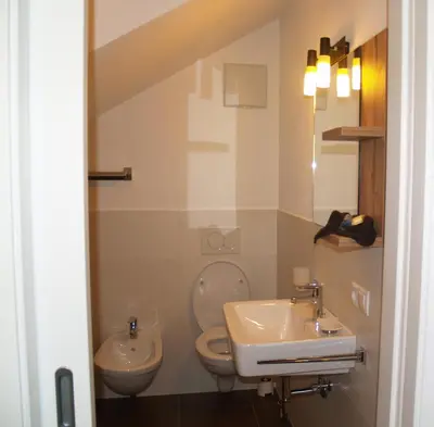 a bathroom with a toilet and a sink at Cafe Schneider in Lappago