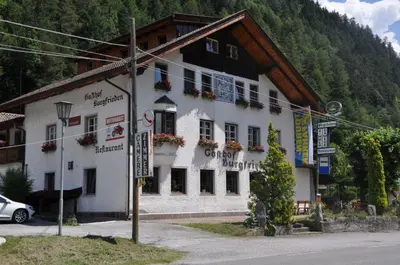a large white building with flowers on the windows at Burgfrieden in Vipiteno