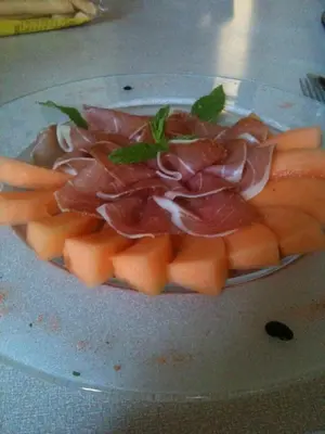 a plate of food with ham and carrots on it at Burgfrieden in Vipiteno