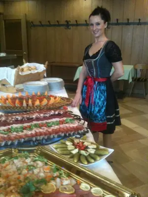 a woman standing next to a buffet of food at Burgfrieden in Vipiteno