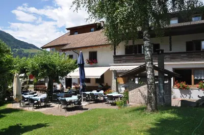 a building with tables and chairs in a yard at Burgfrieden in Vipiteno