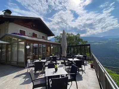 a restaurant with tables and chairs on a balcony at Sturmhof in Chiusa