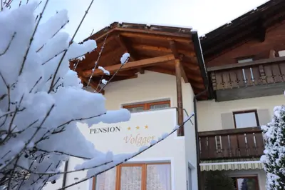 a building with a sign in the snow at Pension Volgger in Rodengo