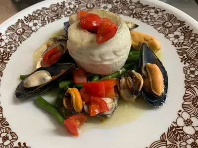 a plate of food with oysters and vegetables on it at Pension Volgger in Rodengo