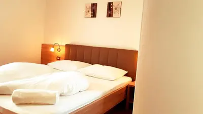 a bedroom with two beds with white sheets and pillows at Pension Volgger in Rodengo