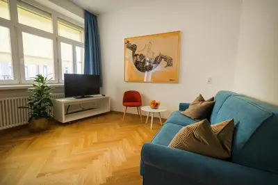 a living room with a blue couch and a television at App110 in Merano