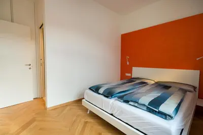 a bedroom with a bed with a orange headboard at App110 in Merano