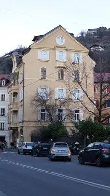 a building with cars parked on the side of a street at App110 in Merano