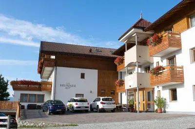 a large building with cars parked in a parking lot at Der Brunnerhof in Mühlbach