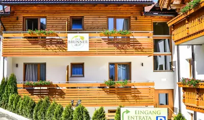 a building with potted plants on the balconies at Der Brunnerhof in Mühlbach