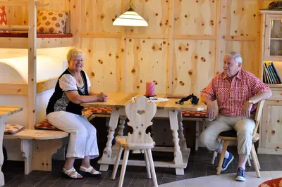 a man and woman sitting at a table in a cabin at Der Brunnerhof in Mühlbach