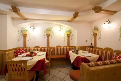 a dining room with two tables and chairs at Hotel Sport in Coredo