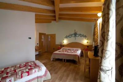 a bedroom with two beds in a room with wooden ceilings at Hotel Sport in Coredo