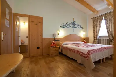 a bedroom with a bed and a chandelier at Hotel Sport in Coredo