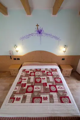 a bedroom with a bed with a cross on the ceiling at Hotel Sport in Coredo