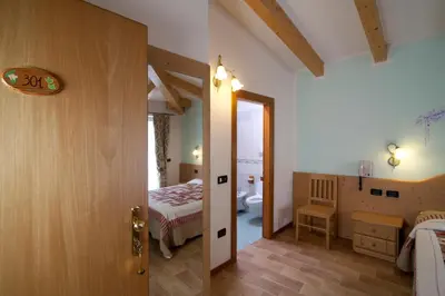 a room with a bedroom with a bed and a bathroom at Hotel Sport in Coredo