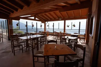 a restaurant with tables and chairs and a view of the ocean at Rifugio Predaia Ai Todes'ci in Tres