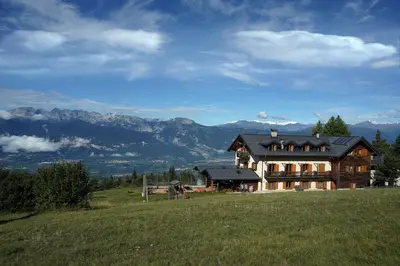 a large wooden house on a hill in a field at Rifugio Predaia Ai Todes'ci in Tres