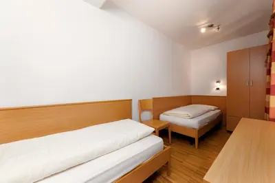 a small room with two beds and a table at Apartments Samberg in Eggen