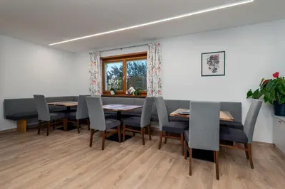 a dining room with tables and chairs and a window at Apartments Samberg in Eggen