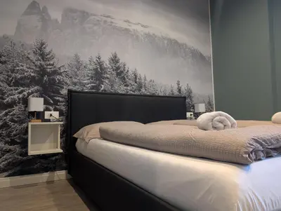 a bedroom with a bed with a snow covered mountain mural at Casa al Duomo - Domhaus in Bolzano