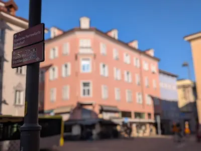 a street sign in front of a large brick building at Casa al Duomo - Domhaus in Bolzano