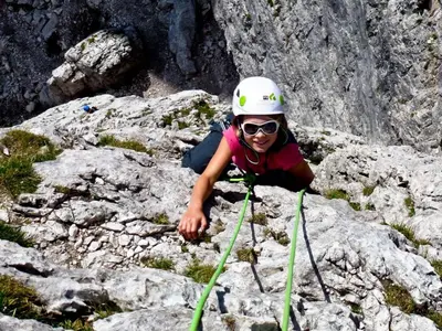 a woman in a helmet on top of some rocks at Hotel Garni Civetta in Selva di Cadore